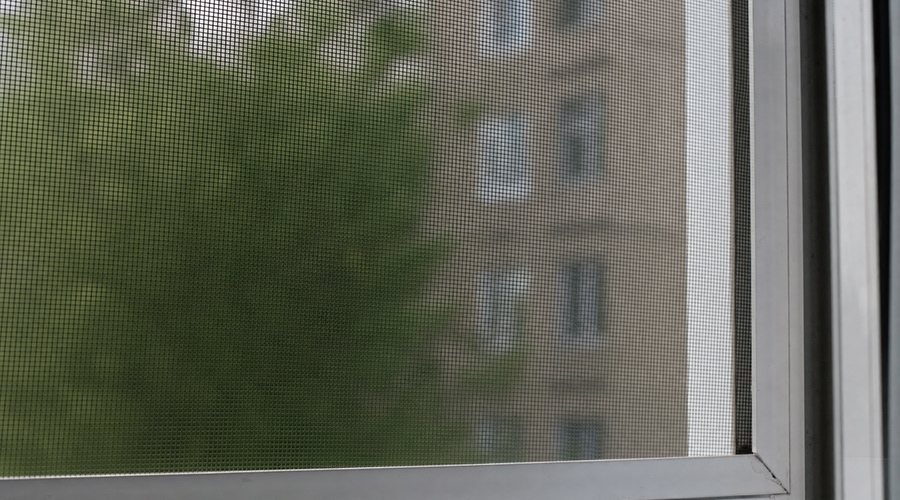 Москитная сетка на пластиковом окне крупным планом